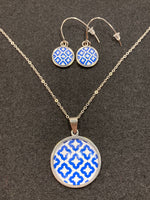 Earrings with blue and white pattern behind glass/stainless steel