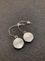 Earrings with blue and white pattern behind glass/stainless steel