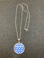Chain with a blue/white pattern behind glass and stainless steel